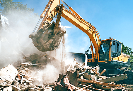 Excavator demolishing building debris